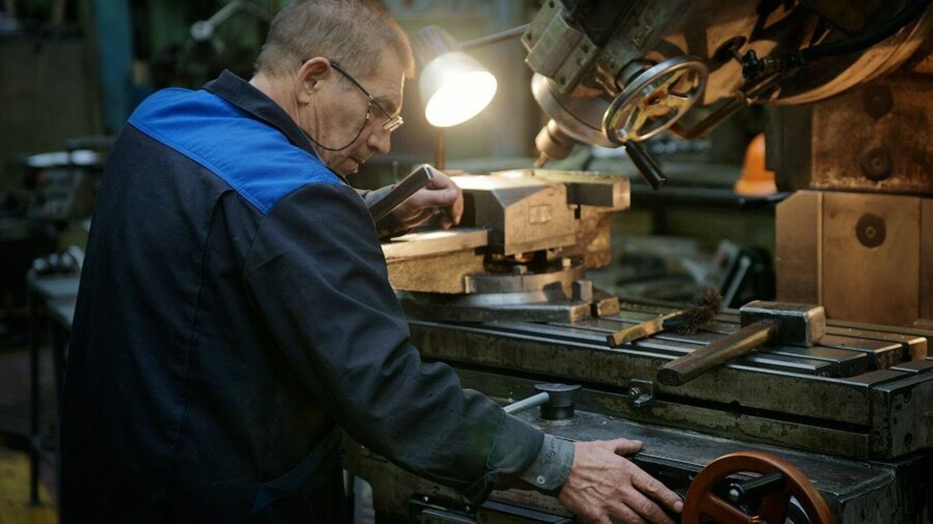 Работа в заводском. Рабочий на заводе. Цех со станками. Станок на заводе. Токарь на станке на заводе.